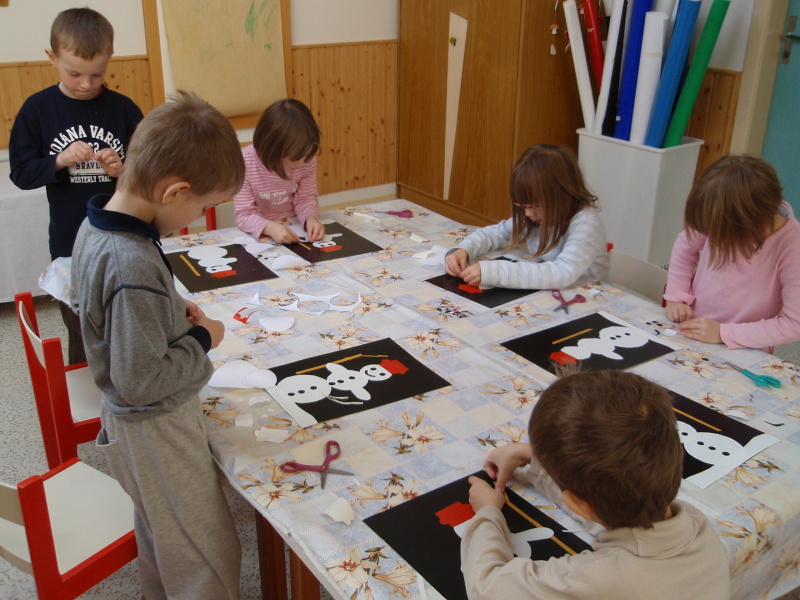 Děti lepící sněhuláky na papír